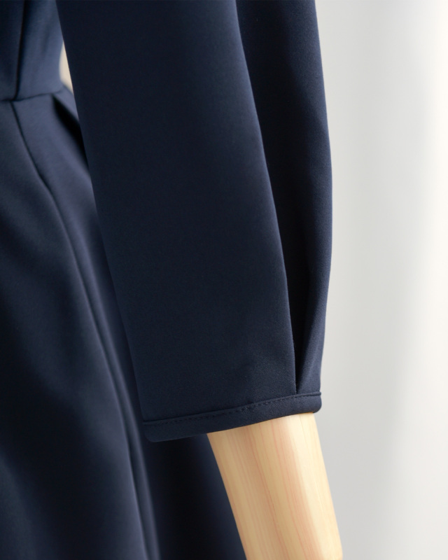 ネイビーワンピースの袖口ディテール、シンプルで清楚なデザインが大人女性に映える