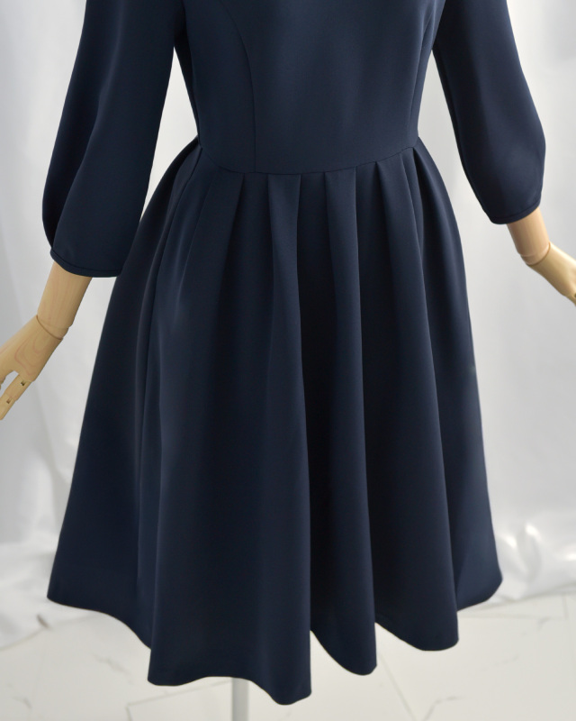 ネイビーワンピースのウエストラインとスカート部分、自然なタックで上品なシルエットに