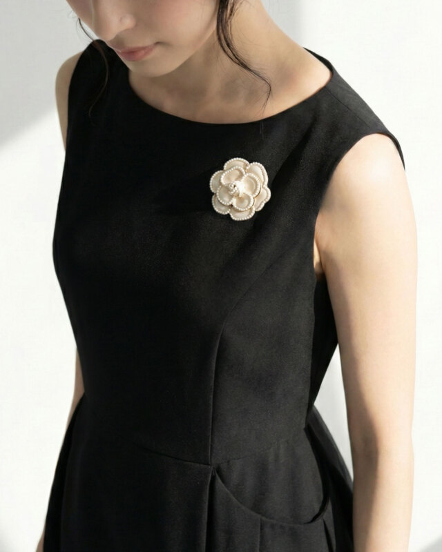 黒ワンピに映えるカメリアパールブローチ、セレモニーにも
