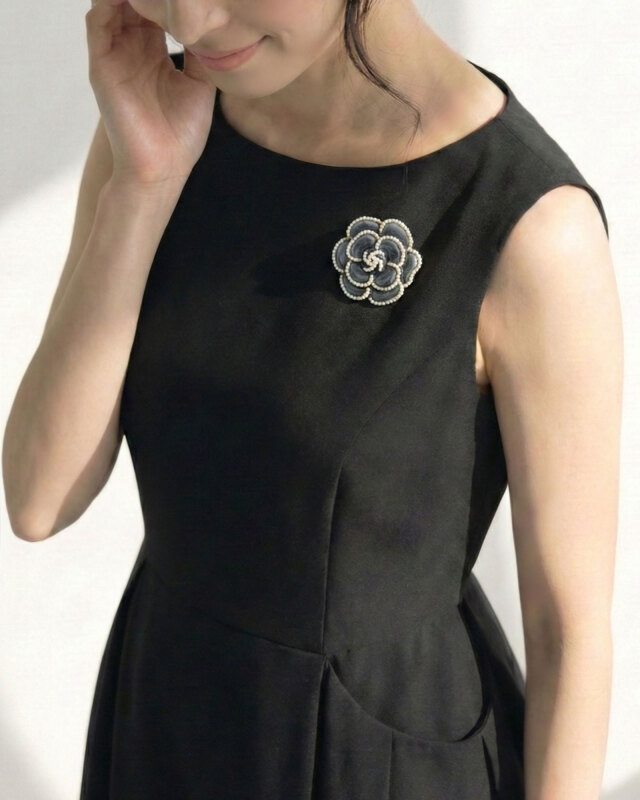 胸元に品格を添えるカメリアパールブローチ、きちんと感を演出