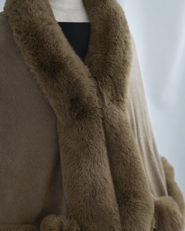 肩から腕にかけてゆとりを持たせ、重ね着しやすいケープデザイン。