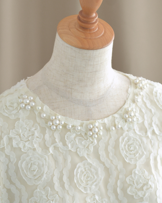 パールが美しく映えるネックラインデザイン。大人の女性にふさわしい華やかさ。