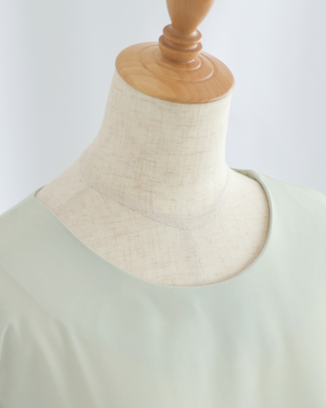 シンプルなラウンドネックがデコルテを美しく見せるデザイン