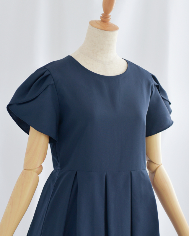 ネイビーのペタルスリーブワンピース上半身アップ、丸首デザインで優しい印象に