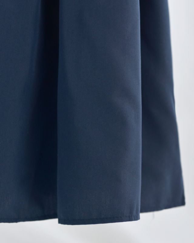 ネイビーワンピースの裾に広がる上品なAラインシルエット