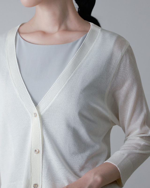 ホワイトカーディガンをワンピースに合わせた着こなし。すっきりとしたVネックデザインが上品。レジーナ【神戸ワンピース専門店】