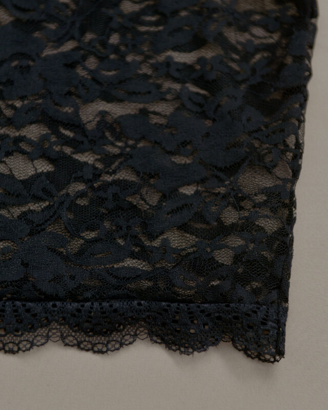 黒レースブラウスの裾アップ、女性らしい雰囲気を演出する素材感