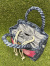 デニムブルー地にピンクとショッキングピンクのエンゼルウイングが大胆に配置されたハワイアンキルトセカンドバッグ。斜め上からの画像