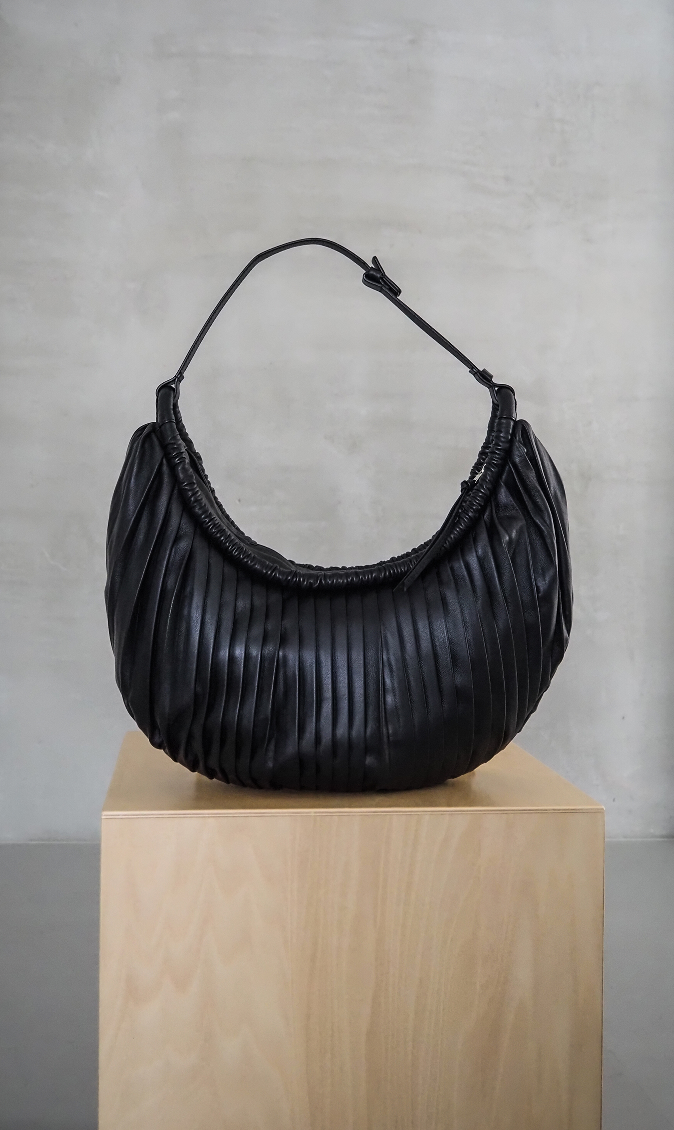 流れるように折りたたまれた柔らかなプリーツディテールが印象的な