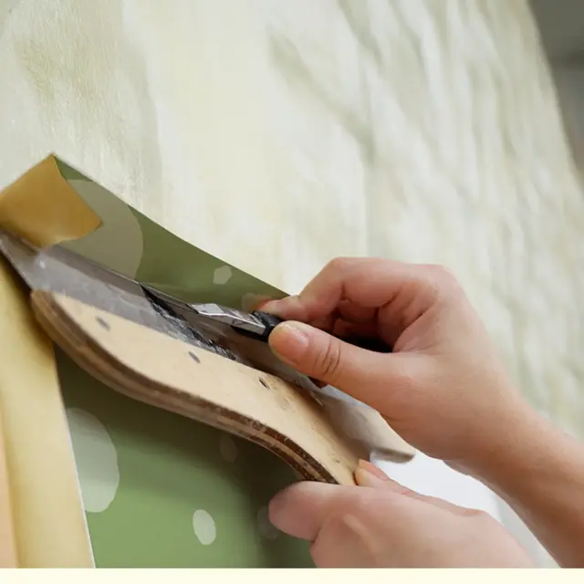 クロスの余分をカッターで切り落とす仕上げ作業